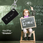 Brainy little boy sitting in front of blackboard. Boy showing the mass-energy equivalence formula on small chalkboard